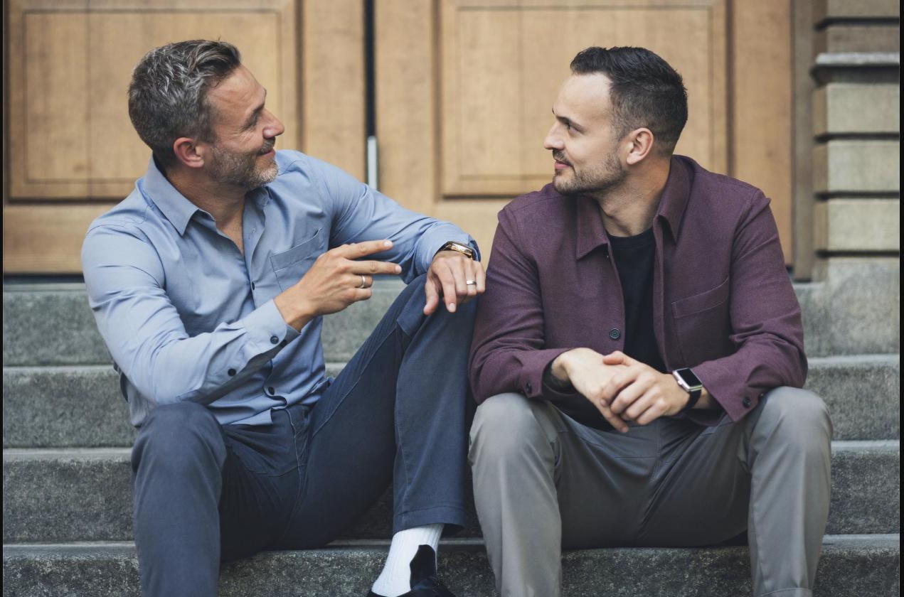 Coach and athlete talking on outdoor steps, working through a setback together
