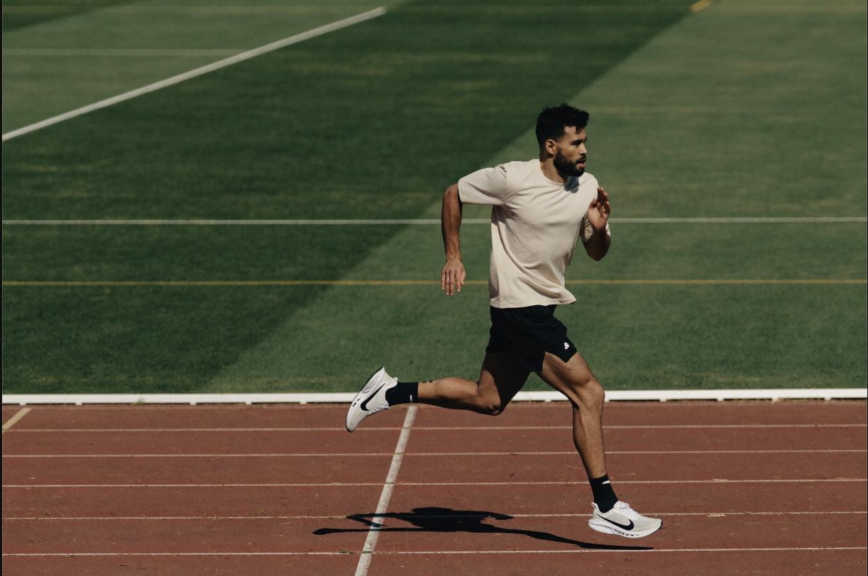 Athlete mid-sprint on a track, focused under competitive pressure