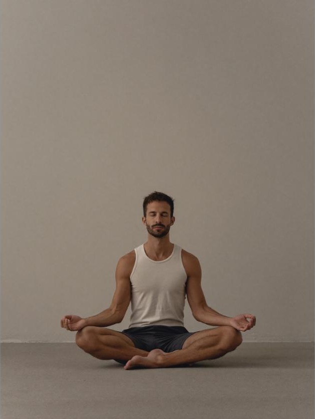 Man sitting quietly in a calm, dimly lit room, winding down in the evening