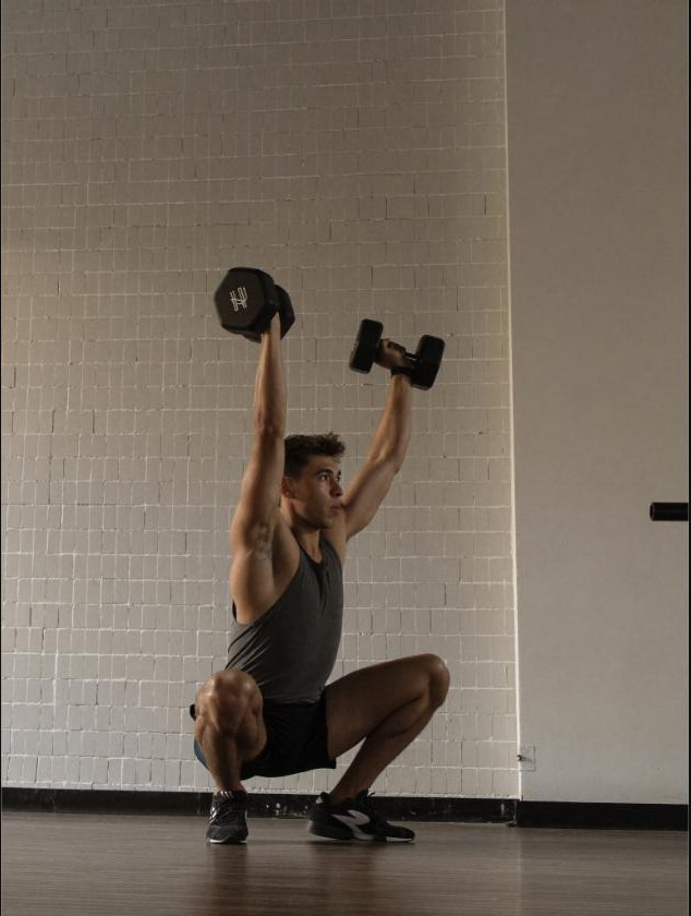 Man performing a controlled goblet squat with a kettlebell, representing deliberate training volume