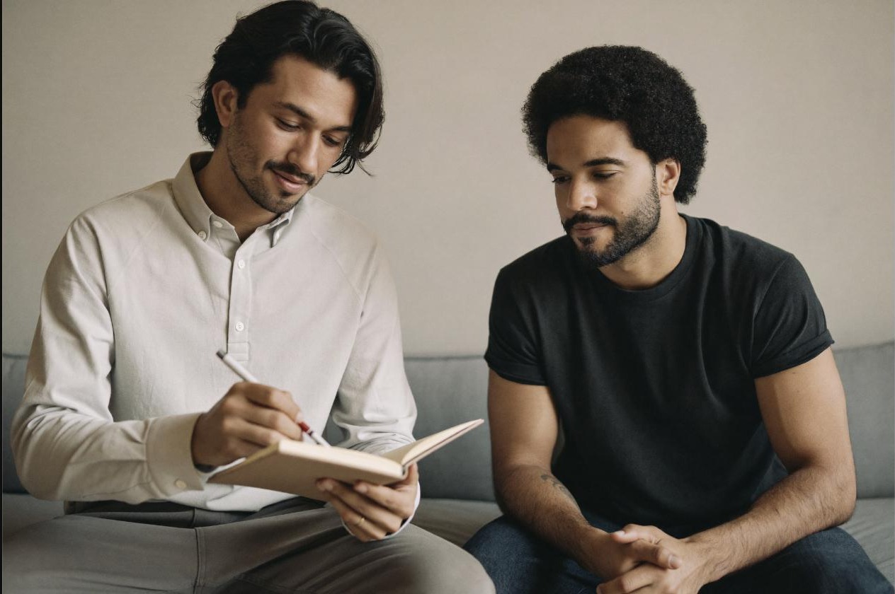 Coach and client planning a weekly training schedule together in a notebook