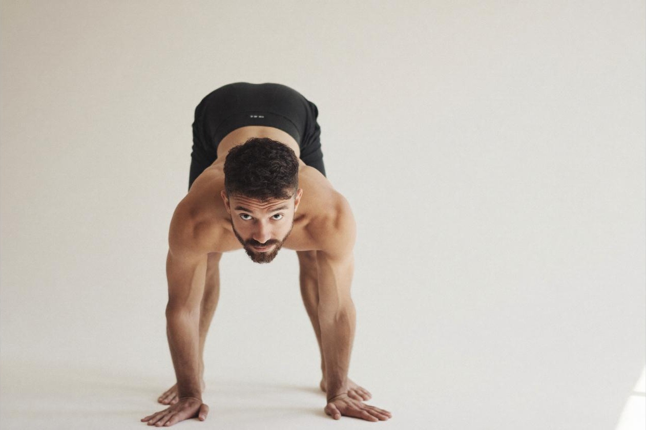 Man in a standing forward fold stretch during a recovery and mobility session